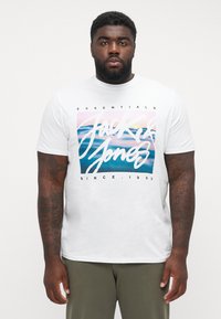 Hvid t-shirt med grafisk tryk af "Jack & Jones" i fedt skrift. Korte ærmer, standard pasform, lavet af bomuld.