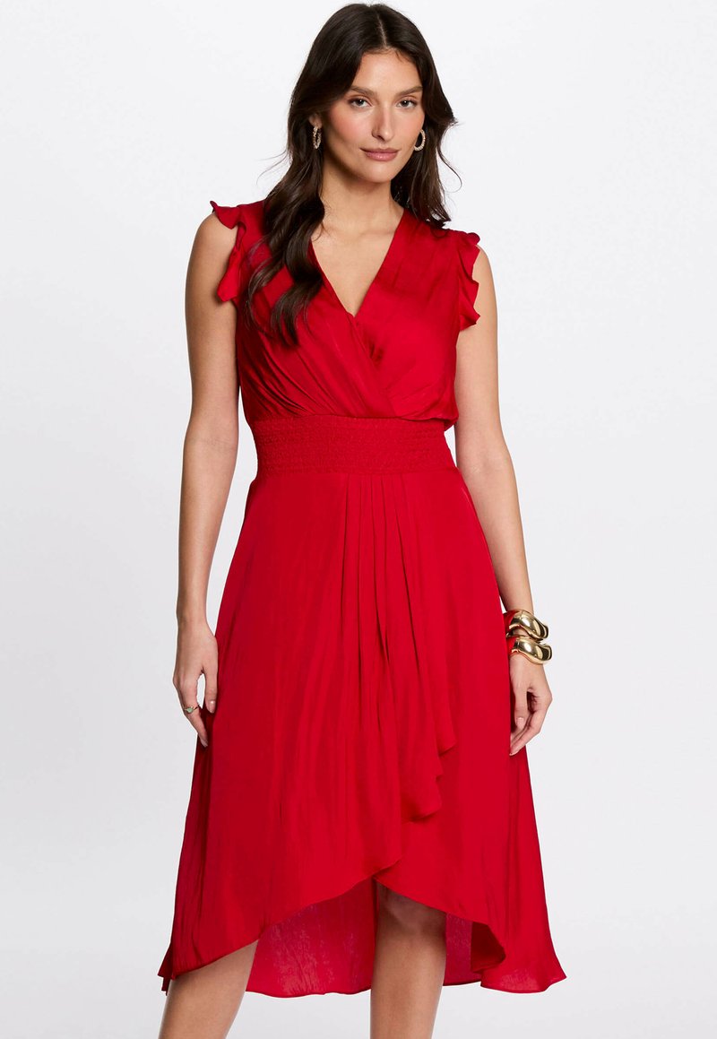 Robe portefeuille rouge avec des manches courtes évasées, une taille smockée et un ourlet asymétrique fluide. Fabriquée en tissu léger et texturé.