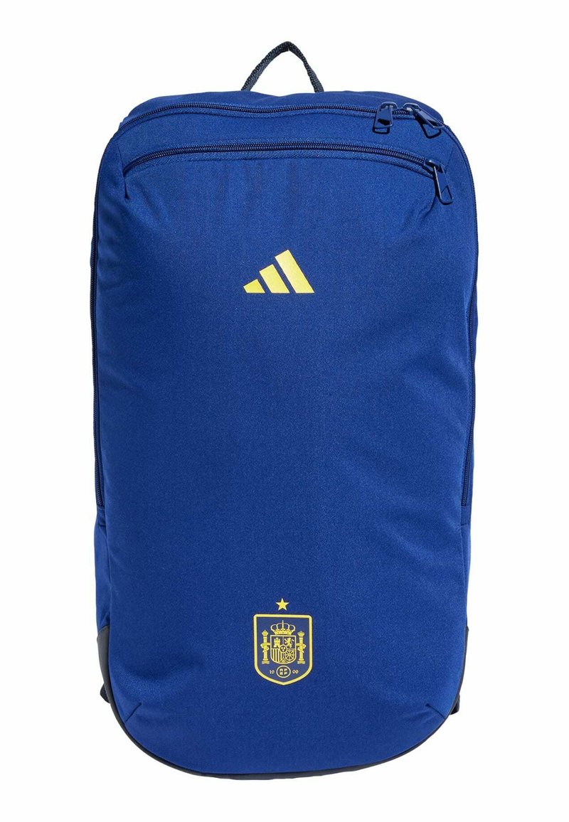 Mochila azul hecha de tela duradera, con un logo amarillo de Adidas, un escudo español y dos compartimentos con cremallera.