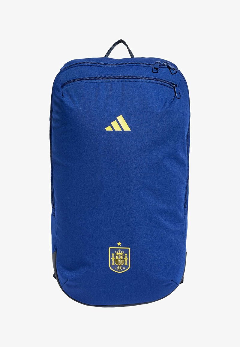 Mochila azul hecha de tela duradera, con un logo amarillo de Adidas, un escudo español y dos compartimentos con cremallera.