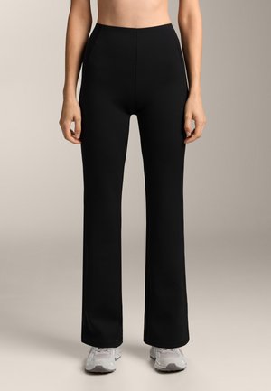 Pantaloni negri stretchy cu talie înaltă, design evazat și buzunare laterale. Textură netedă, potriviți pentru îmbrăcăminte sport.