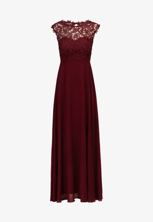 Burgundowa sukienka wieczorowa z koronkowym topem, rękawami typu cap oraz zwiewną spódnicą. Góra sukienki zdobiona jest misternymi wzorami kwiatowymi oraz dopasowaną talią.