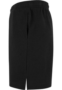 Jupe noire longueur genou avec ceinture élastique, fente latérale et poche latérale discrète, présentée sur un fond blanc.