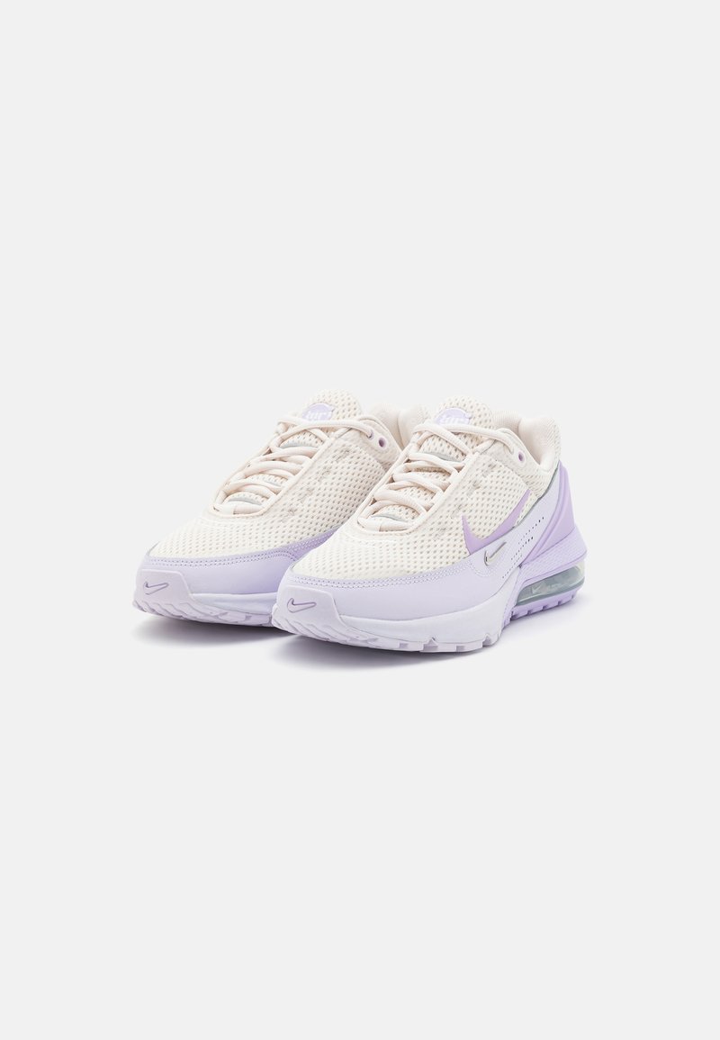 Lekkie siatkowe sneakersy z kremową cholewką i lawendowymi akcentami, zaokrąglonym noskiem oraz widoczną poduszką powietrzną w podeszwie.