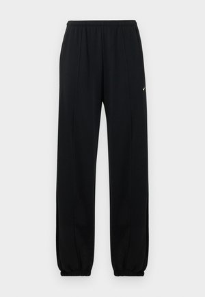 Pantalon de sport noir avec une taille élastique, des poignets resserrés et un petit logo Nike blanc sur la cuisse gauche. Texture de tissu lisse.