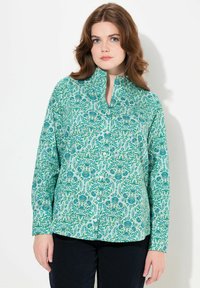 Camisa de botones turquesa con patrón floral en verdes y azules, que cuenta con cuello tipo mao y mangas largas. Material de algodón suave.
