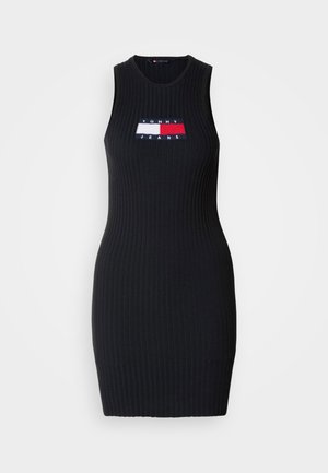 Black ribbed sleeveless dress featuring a logo patch in red, white, and blue. It has a fitted silhouette and a crew neckline.