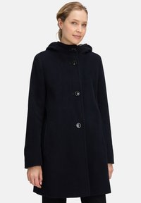 Marineblauwe wollen jas met een capuchon, vijf knopen aan de voorkant, zijzakken en een rechte snit. Zachte textuur en minimalistisch ontwerp.