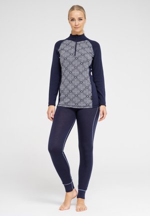 Marine termisk top med et mønstrede gråt torso og høj krave, parret med tætsiddende marine leggings med kontrast detaljer på siden.