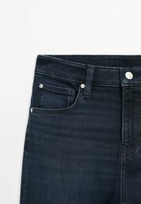 Dark denim jeans with a straight cut, featuring a front pocket, metal button closure, and minimalistic design. Smooth texture, no patterns.