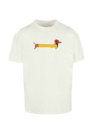 T-shirt en coton blanc avec un dessin d'un dachshund en forme de jaune, portant un chapeau rouge et une écharpe verte, imprimé au centre.