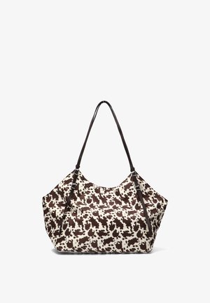 Bolso grande tipo tote con un diseño de estampado de vaca en marrón y crema, fabricado con tela suave, con dos asas marrones y una forma relajada.