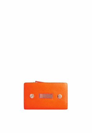 Pochette rectangulaire orange avec deux clous métalliques hexagonaux et un détail central en maille, fermée par une fermeture éclair sur le dessus.