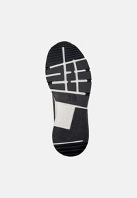 Black rubber shoe sole with white accents, featuring textured grip patterns and prominent 'CAMPER' logo. Size marked as 38.