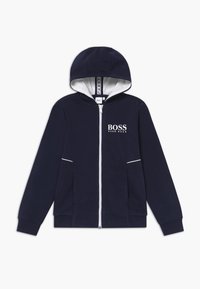 Navy blue zip-up collegepaita, jossa on valkoinen vuorihuppu, rintataskussa 'BOSS' logo, kaksi etutaskua ja valkoiset koristeompeleet saumoissa.