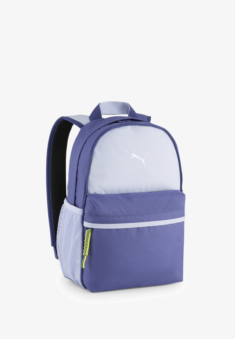 Lila szövet hátizsák, szürke elülső panellel, hálós oldalsó zsebbekkel, cipzáros elülső zsebbel és sárga-zöld zsinór díszítéssel.