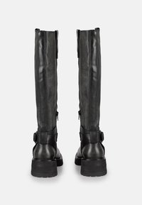 Bottes noires en cuir montant jusqu'aux genoux avec une finition texturée, des fermetures éclair latérales et des accents de boucles au niveau de la cheville. Talon épais pour plus de stabilité.