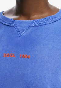 Felpa blu con collo rotondo, tessuto testurizzato e testo stampato rosso "DSGL 1984" sul fronte.
