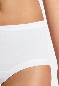 Slip hipster bianchi in cotone con un elastico morbido e una texture soffice, caratterizzati da un design liscio e senza cuciture, senza motivi visibili.