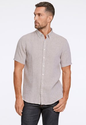 Kortebloes, lichtbeige knoopshirt met een gestructureerde stof en kleine kraag, gecombineerd met donkere jeans, slim fit ontwerp.