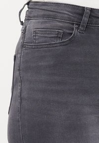 Grå denimjeans med slim fit, mid-rise midjebånd og klassisk fem-lomme design med subtile sømdetaljer.