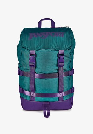 Sac à dos Jansport vert et violet avec poignée supérieure, boucles frontales, sangles latérales réglables et compartiment principal zippé.