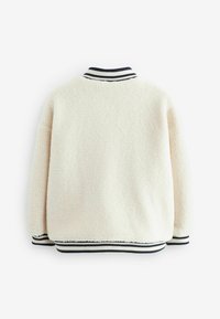 Kerman fleece-takki, jossa on ribbaus sinisessä ja valkoisessa kauluksessa ja hihoissa. Pehmeä pinta, rento istuvuus ja ei näkyvää metalliosaa tai kiinnitystä.