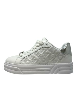 Sneakers bianchi con branding testurizzato e in rilievo sul lato. Materiale sintetico liscio, punta rotonda e suola piatta in gomma con un design più spesso.