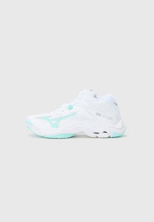 White athletic shoe with mint green accents, featuring a textured sole, structured design, and lace-up front. Lightweight synthetic material.