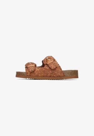 Sandalia slide de cuero trenzado marrón con dos correas decorativas y suela de corcho. Presenta un acabado texturizado y diseño de tacón bloque.