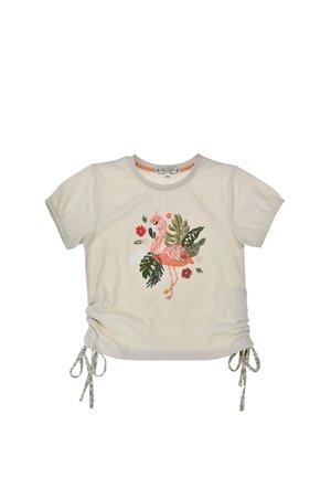 Beige short-sleeve children's shirt with ruched sides tied by strings and a central pink flamingo surrounded by green leaves and red flowers.