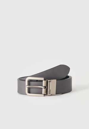 Mørkegråt læderbælte med spænde i sølv rektangulært med graveret "KARL LAGERFELD JEANS,", snoet på en lys baggrund.