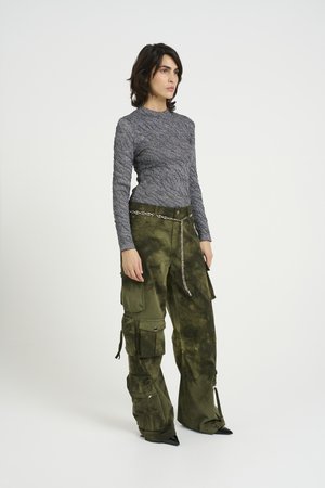 Gray patterned long-sleeve top paired with tie-dye olive green cargo pants. Features include a chain belt and tapered pant leg openings.