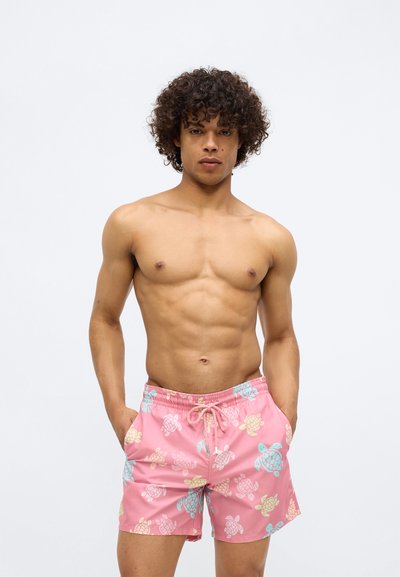 Șorturi de baie roz cu un model de broaște țestoase în culori pastelate. Confecționate din material ușor, cu o talie ajustabilă și buzunare laterale.