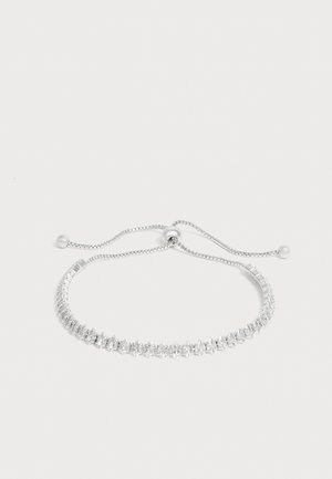 Pulsera ajustable de tono plateado con piedras preciosas redondas y transparentes en una sola fila y cierre deslizante con dos extremos de cuenta.