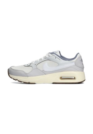 Zapatilla deportiva gris con parte superior de cuero y textil, que presenta detalles en blanco, un cojín de aire visible y una suela de goma con surcos de tracción.