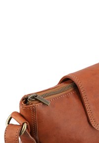 Borsa in pelle marrone con una texture liscia, dotata di chiusura a zip e dettagli in ottone. Include cuciture visibili.