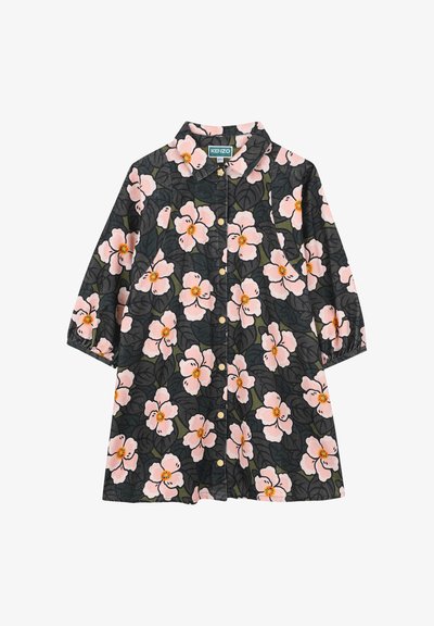 Chemise noire à manches courtes ornée de motifs floraux roses et oranges, avec un col pointu et des fermetures à boutons dorés.