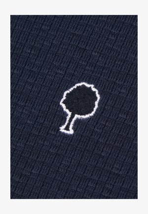 Marineblauw ribbenstof met een klein geborduurd bomenlogo in zwart, omlijnd met wit. Gladde textuur met een subtiel patroon.