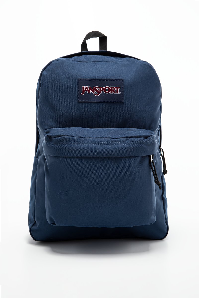 Blå Jansport ryggsekk med lomme foran med glidelås, tykt stoff, polstret bakside og svarte detaljer. Har en logo-patch på forsiden.