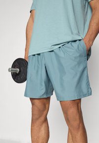 Under Armour TECH WOVEN WORDMARK - Korte sportsbukser - jasper blue/white