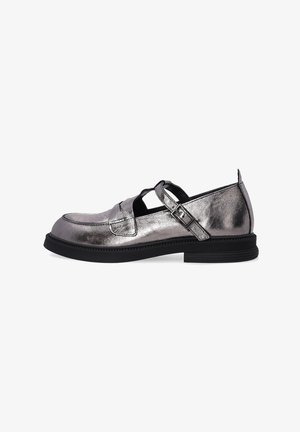 Metallisch grauer Slipper mit einer niedrigen schwarzen Sohle, der ein Ausschnittdesign und einen verstellbaren Riemen mit Schnalle an der Seite aufweist. Glatte Textur.