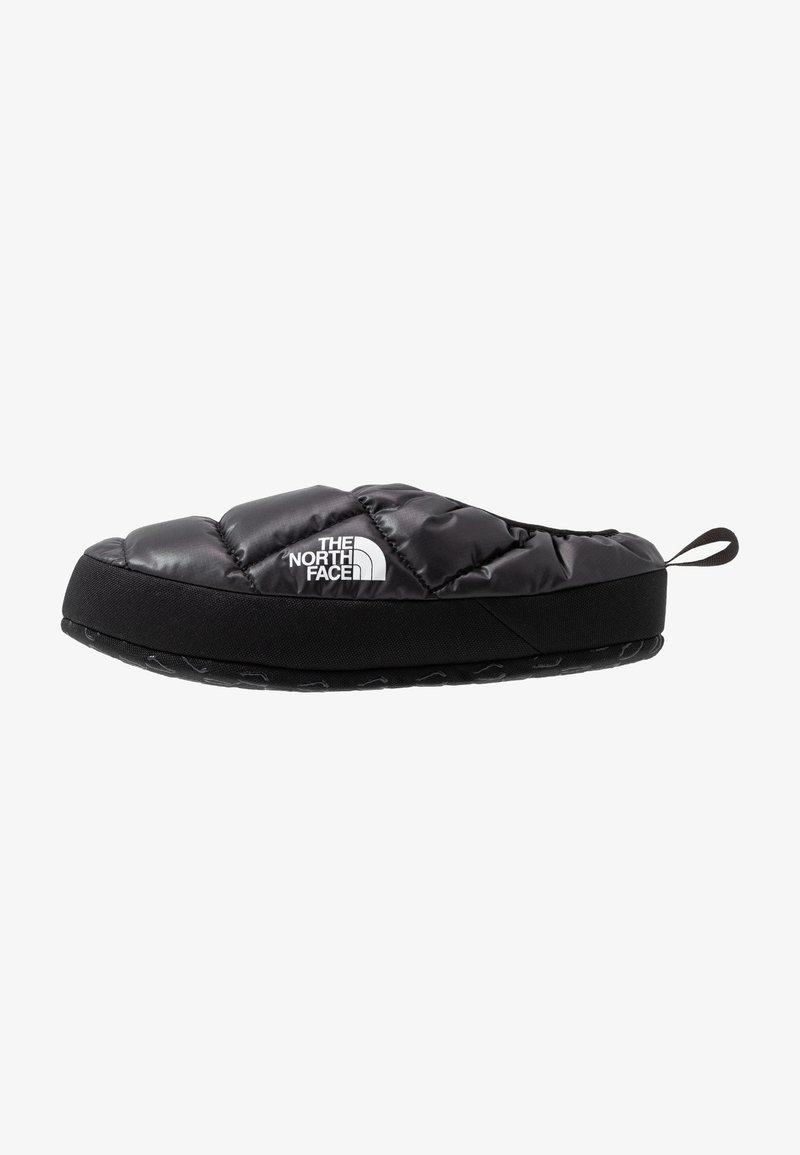Chausson slip-on isolant noir avec dessus matelassé, logo The North Face et semelle en caoutchouc noire avec une languette arrière.