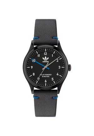 Melnā saules enerģijas rokas pulksteņa ar apaļu seju, baltiem stundas marķieriem, zilas akcenta otrajā rokā un teksturētu pelēku ādas siksniņu.