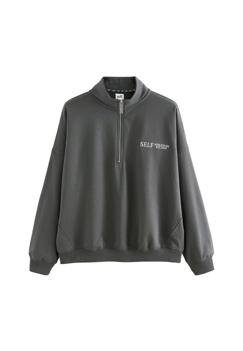 Pelēks, garām piedurknēm, sporta krekls ar augstu apkakli un pusi rāvējslēdzēja aizdari. Uzprasts teksts "SELF ATHLEISURE EST.2023" baltā krāsā uz priekšpuses. Kokvilnas maisījuma materiāls.