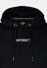 Felpa nera con cappuccio e cordino, con un logo stampato in argento "PETROL" sulla parte anteriore. Tessuto testurizzato con un interno morbido.