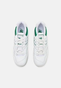 Vita lädersneakers med gröna accenter, med en textured finish, snörning och synlig logotyp på tungan och sidan.