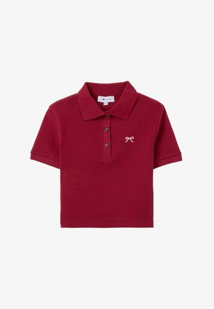 Rotes Poloshirt aus Baumwolle mit einem Kragen, drei braunen Knöpfen und einem kleinen gestickten Bogen auf der linken Brust. Kurze Ärmel, gerippte Textur.