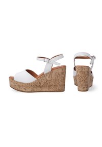 Sandales compensées blanches avec une plate-forme en texture liège, design à bout ouvert et bride ajustable à la cheville. Matériau lisse avec un éclat subtil.