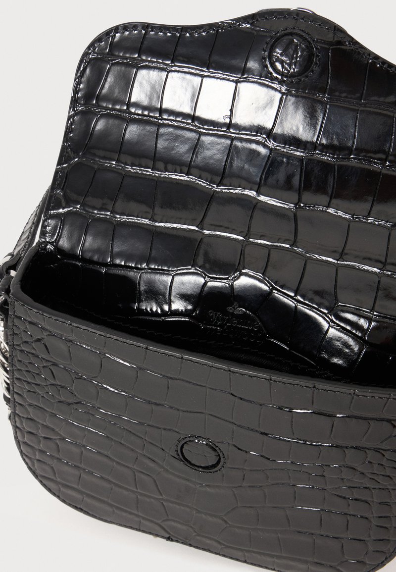 Black glossy croc-embossed leather handbag with flap open, showing interior and magnetic snap closure on front.